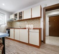 A kitchen with a wooden decor floor in a 3-room apartment, equipped with light furniture.