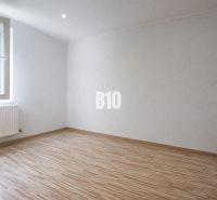 A room in a 3-room apartment with a wooden decor floor and white walls.