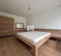 A bedroom in a two-room apartment with wooden furniture and a floor with a wood decor.