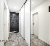 A hallway with white walls, a sliding wardrobe, and a stone floor in a 3-room apartment.