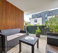A balcony of a 3-room apartment with rattan furniture and plants.