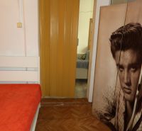 A room in a 2-room apartment with a bed, a floor with a wooden decor, and sliding doors.