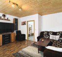 Living room with a sofa set and wood-patterned flooring in a 4-room apartment.