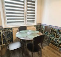 Dining area in a 4-room apartment with floral wallpaper and a table for four.