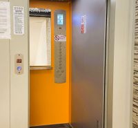 Open elevator in a 4-room apartment building with an orange interior.