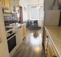 A kitchen in a 4-room apartment with a kitchen unit and a floor with a wooden decor.