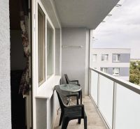 A balcony with plastic furniture at a 4-room apartment.