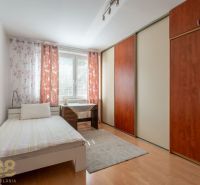 A bright room in a 3-room apartment with a large wardrobe and a desk.
