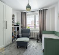 A bright room with a chair, bed, wardrobe, and decorations in a 3-room apartment.