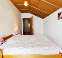Bedroom in a family house with a double bed and wall lamps.