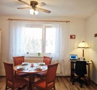 Dining room with a dining table, chairs, and wooden decor flooring in a family house.