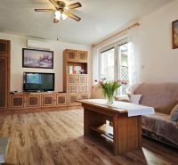 Living room in a family house with a wood-patterned floor and comfortable seating.
