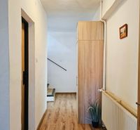 A hallway with a wood-patterned floor in a family house.