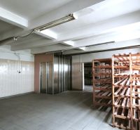 Manufacturing premises with a tiled floor, wooden shelves, and an elevator.