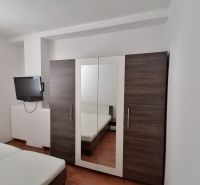 Bedroom with a TV, wardrobe, and bed, 2-room apartment.