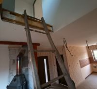 Interior renovation in a family house, dominated by stairs and wood-burning stove.
