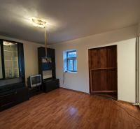 Living room with a dark wall unit and wooden decor flooring in a family house.