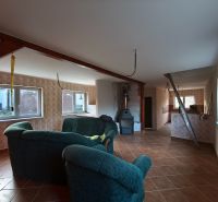 Living room in a family house with a fireplace and a floor with a wooden decor.