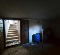 Garden storage in a family house with concrete stairs and a blue container.