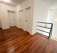 Interior of a family house with a wooden decor floor and white doors.