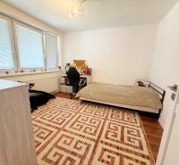 A room in a family house with a carpet pattern and a wooden decor floor.