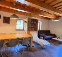 The interior of a cabin with a wood-decorated ceiling, comfortable furniture, and decorative lighting.