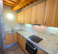 A kitchen in a cottage with a wooden ceiling and a floor with a wooden decor.