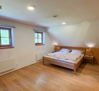 A room in a cabin with a wooden decor floor and a double bed.