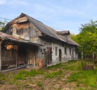 An older family house in the village of Čelovce, surrounded by greenery and wooden annexes.