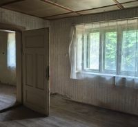 An old interior in a family house with wooden flooring and curtains on the windows.