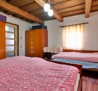 A bedroom in a family house with a wooden ceiling, cabinets, and a light fixture.