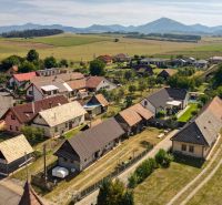 Žabokreky: Panorama of family houses with a rural character and hills in the background.