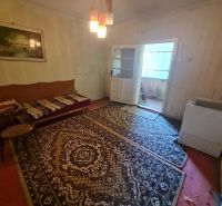 A room in a family house with carpets, lighting, and a sofa.