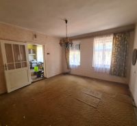 Living room in a family house with carpeted floor and antique chandelier.