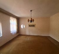 The interior of a family house with carpeted flooring, light, and curtains on the windows.