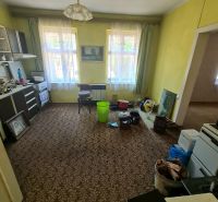 Living room with carpet decor, furniture, and plastic buckets in a family house.