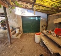 A garage at a family house in Dolné Otrokovce with a metal gate and a shelter.
