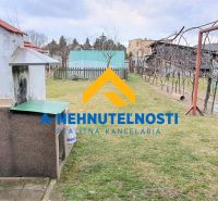 The yard of a family house in Veľký Meder with an outdoor fireplace and a gazebo on the grass.