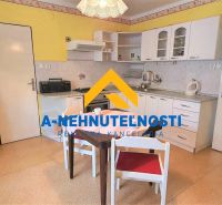 A kitchen in a family house with white cabinets and a dining table.