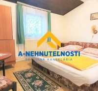 Bedroom in a family house with a carpet, bed, and wooden table.