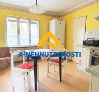A kitchen in a family house with a wooden decor floor and yellow walls.
