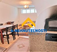 Interior of a family house with a dining table, wooden decor flooring, fireplace.