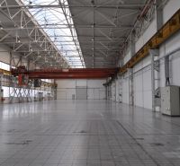 Spacious manufacturing spaces with high ceilings and concrete floors.