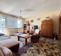 Living room in a family house with wooden furniture and a decorative carpet.