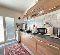 A kitchen in a family house with a kitchen unit and appliances, and a floor with a wooden decor.