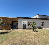 A family house in Kláštor pod Znievom with a wooden extension and a lawn on a sunny plot.