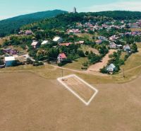 Picturesque landscape of Podhradie, residential plots nestled in green hills.