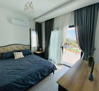 A bedroom in a family house with a large bed and a floor with a wooden decor.