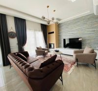 Living room in a family house with a luxurious sofa, carpet, and a large television.