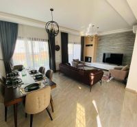 Living room with a dining table, sofa, and large TV in a family house.